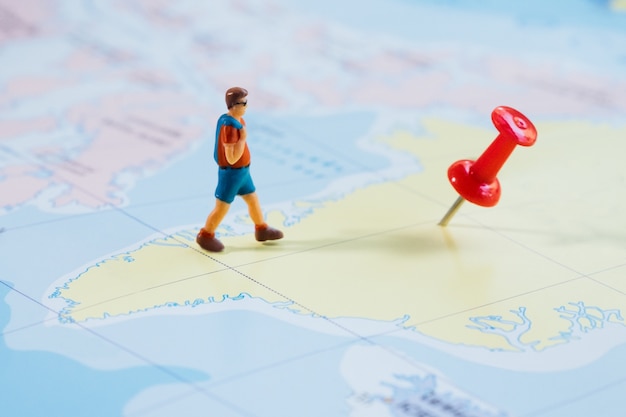 Free photo mini figure traveler with red pushpin and a map travel concept