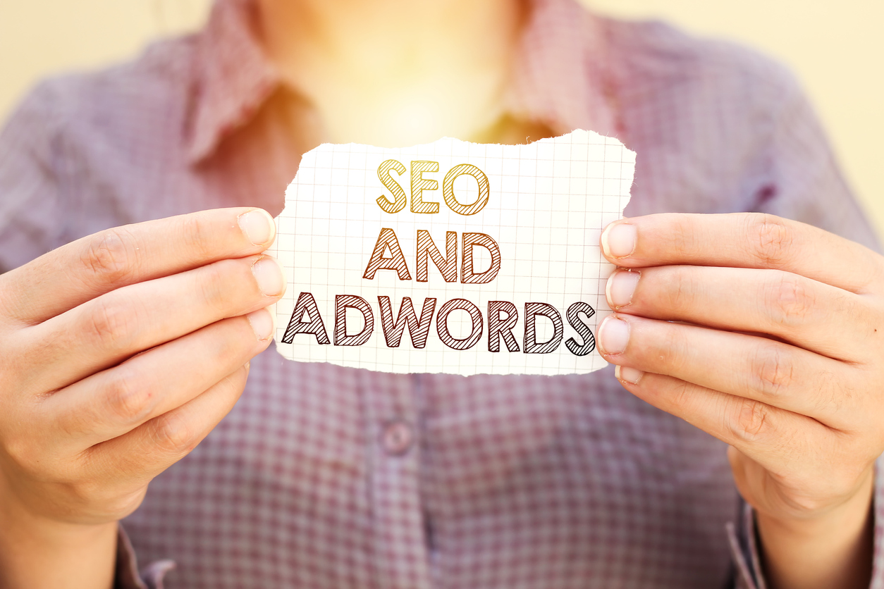 business woman holding tear paper with SEO AND ADWORDS text