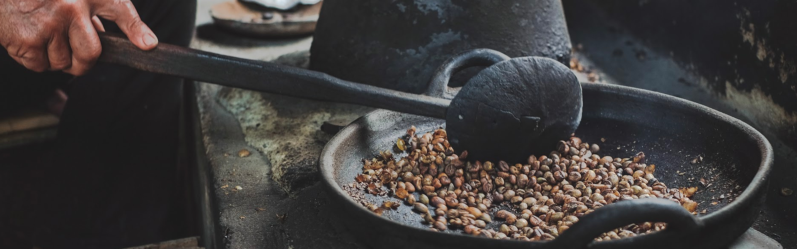 Coffee beans roasting in a clay pan