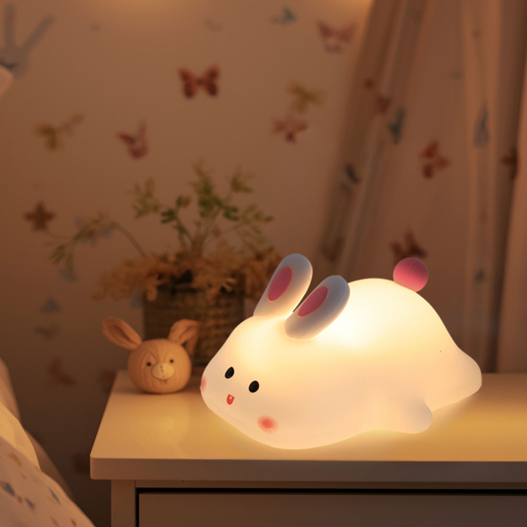Kawaii silicone bunny night light on a nightstand
