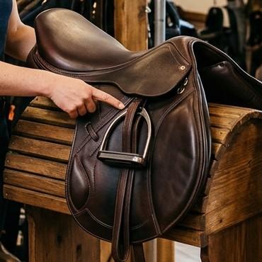 Monoflap dressage saddle on a wooden saddle stand