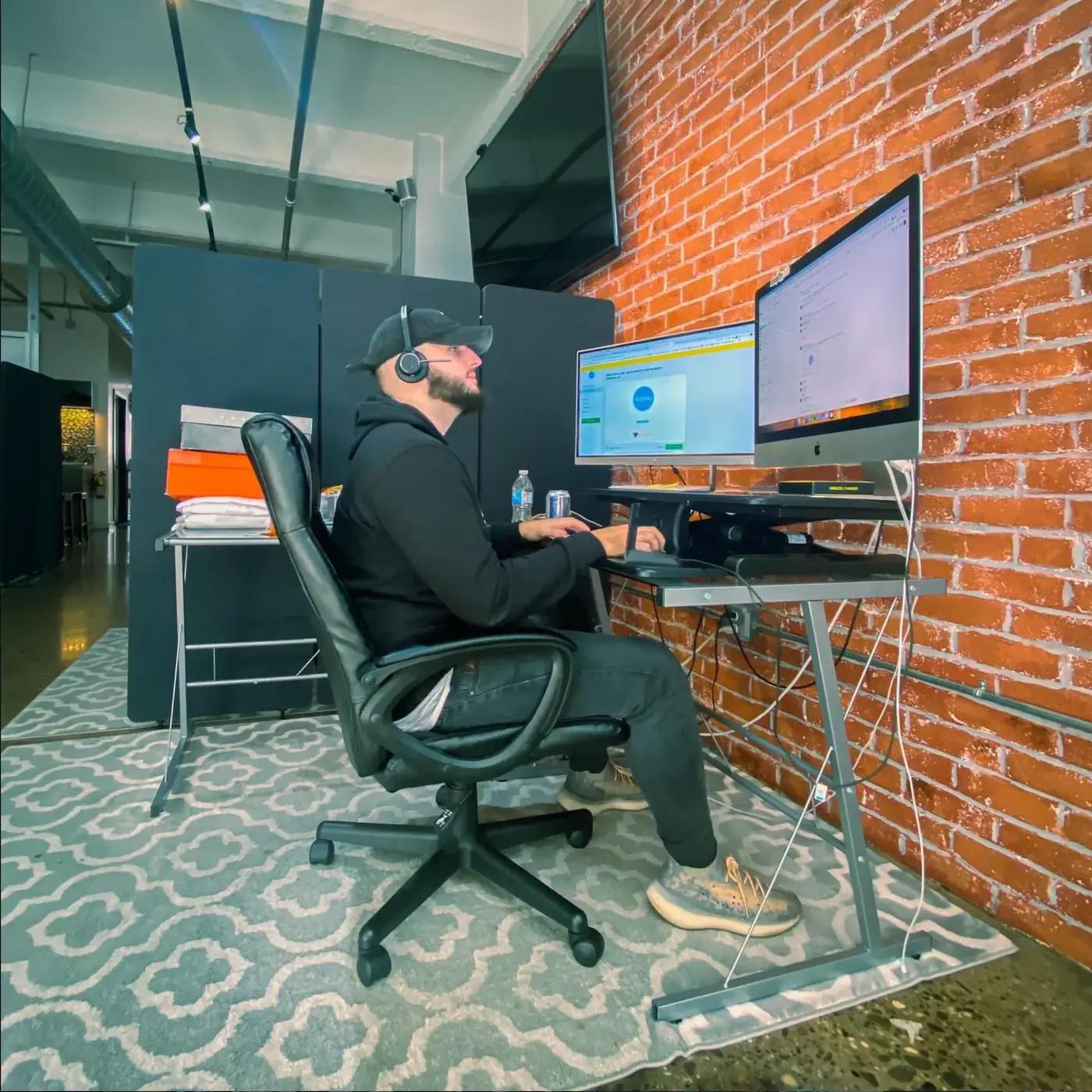 A strategist working across two monitors in an office