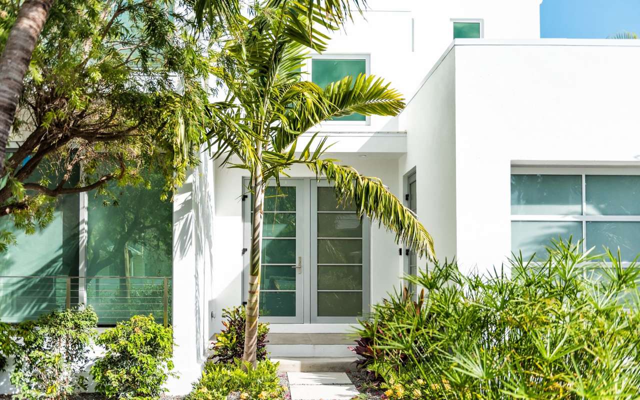 A white contemporary Miami residence behind palms