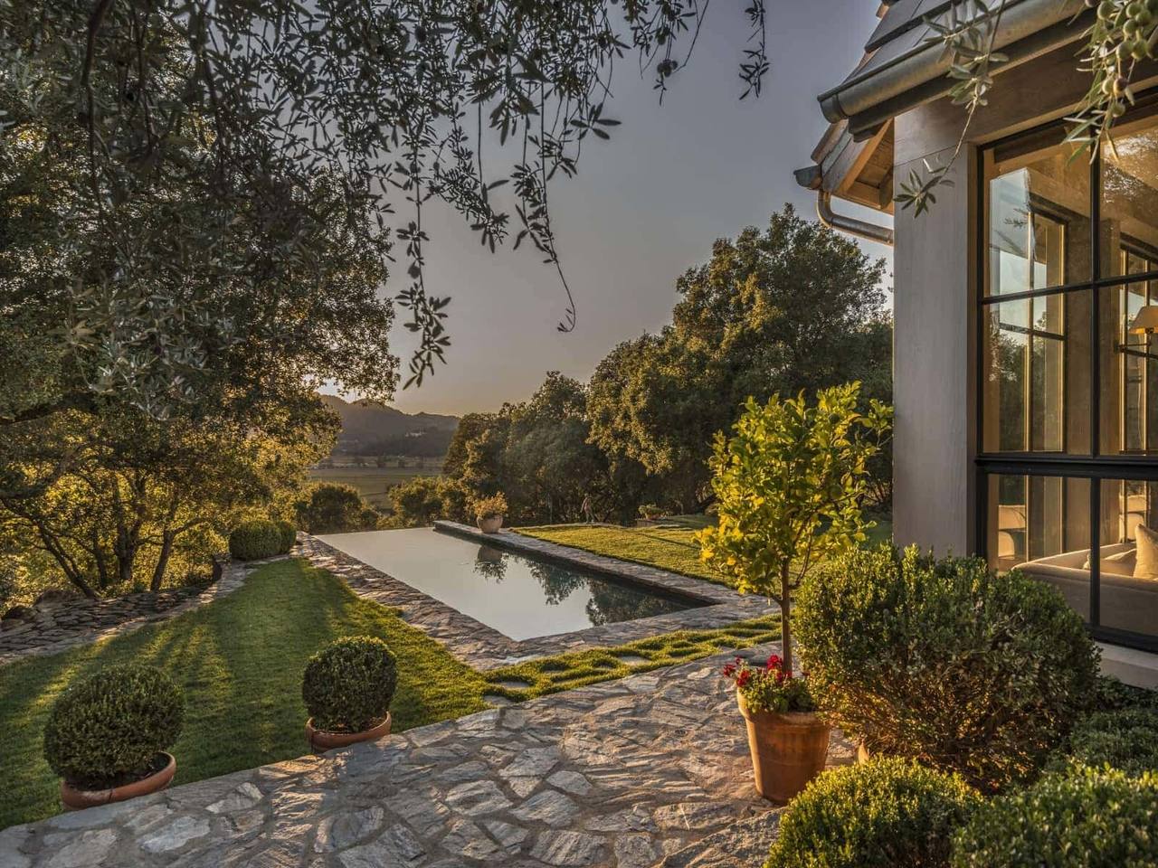 A reflecting pool and garden beside a Miami residence at dusk