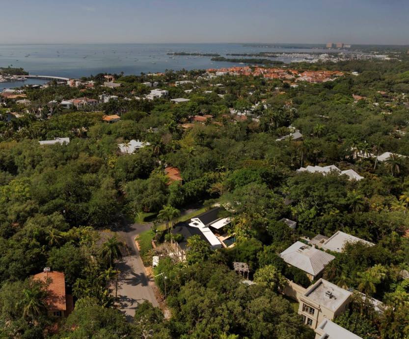 Aerial view over Coconut Grove's tree canopy toward Biscayne Bay and the Dinner Key marina