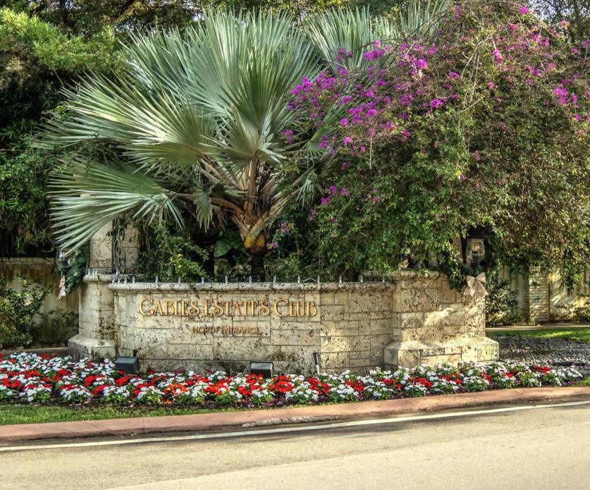The Gables Estates Club entrance in Coral Gables, framed by bougainvillea and mature palms