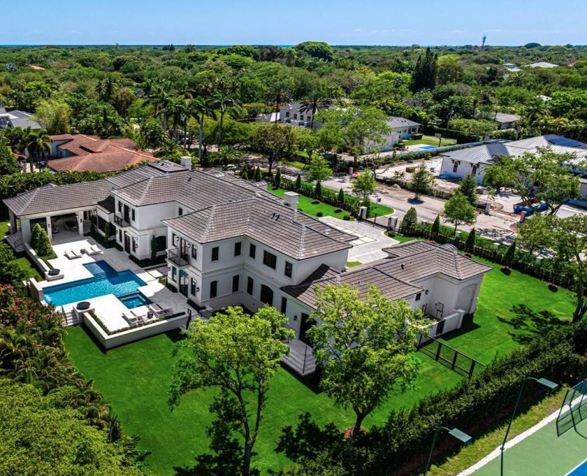 Aerial view of a modern Pinecrest estate with a pool, wide lawn and tennis court