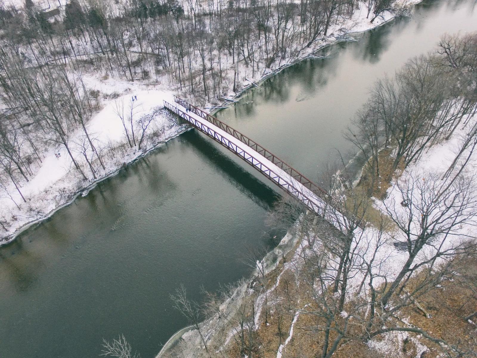A footbridge over a river in winter