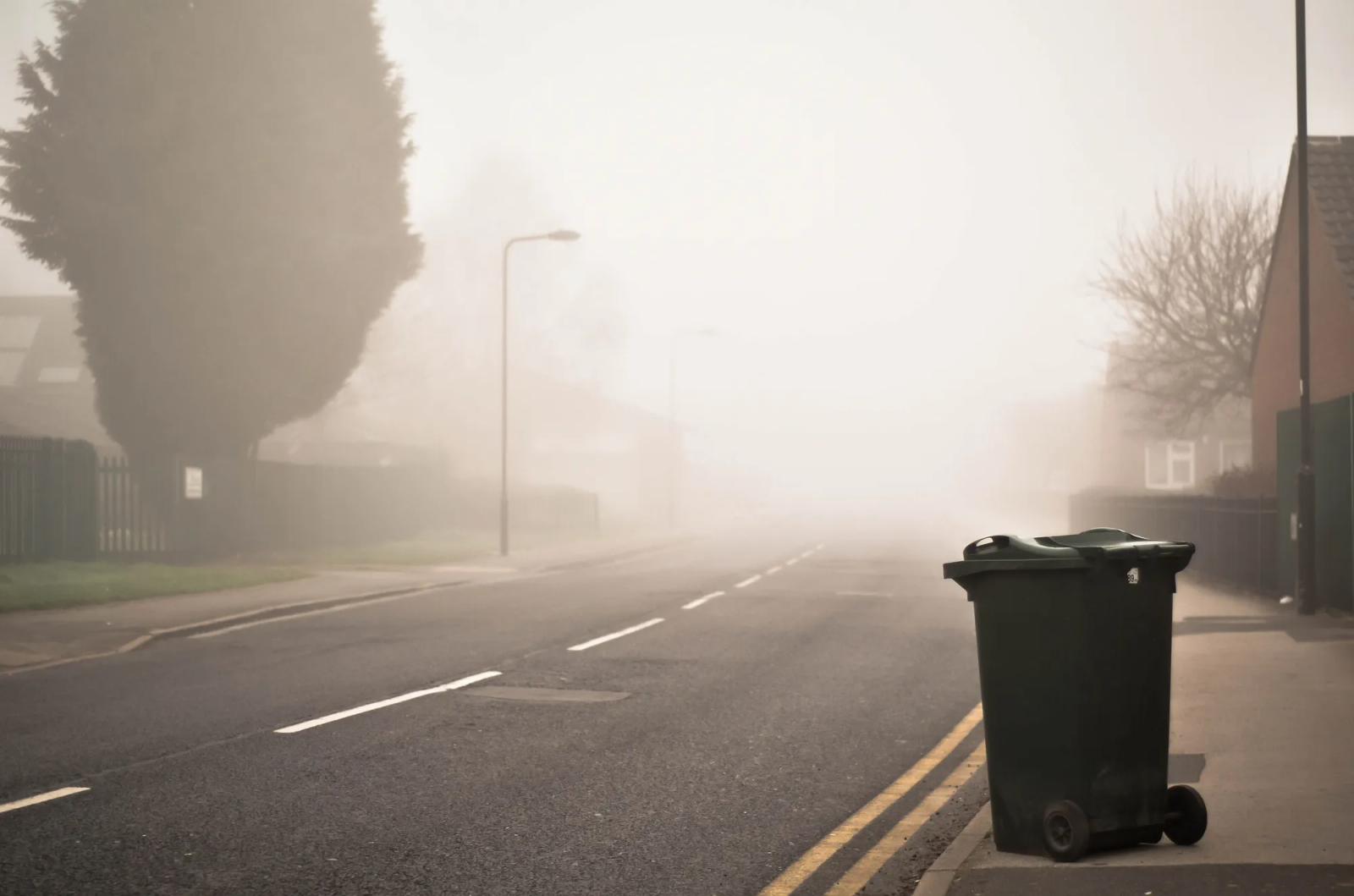 A quiet suburban street in morning fog